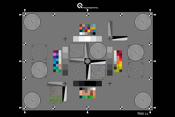 A standardized camera testing chart with gray, white, and color patterns including resolution wedges, color swatches, and noise texture