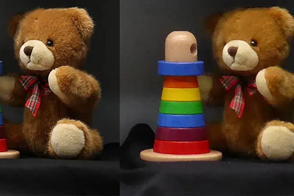 Two teddy bears flank a colorful stacking toy, demonstrating camera performance for standardized camera testing